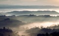 Sunrise over grenn hills of Italy. Misty morning over rural landscape with gardens, farms, fields in Tuscany province