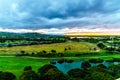 Sunrise over the horizon with sun peeking under dark morning clouds Royalty Free Stock Photo