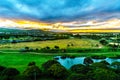 Sunrise over the horizon with sun peeking under dark morning clouds