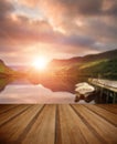 Sunrise over lake with boats moored at jetty with wooden planks Royalty Free Stock Photo