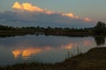 Sunrise over the lake with reflection of bare trees in the water. Royalty Free Stock Photo