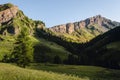 Sunrise over the mountain meadows, trees and peaks of the italian alps, in piedmont