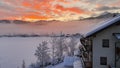 Sunrise over Snowy Mountains With German looking Building against a red and Yellow Sky