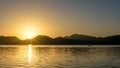 Sunrise over mountains and lake with canoeist Royalty Free Stock Photo