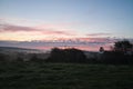 Sunrise over a neighboring forest with meadow in the foreground. Pasture landscape Royalty Free Stock Photo