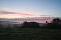 Sunrise over a neighboring forest with meadow in the foreground. Pasture landscape Royalty Free Stock Photo