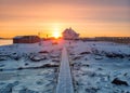 Sunrise over nordic house and wooden bridge on coastline in winter at Lofoten Islands Royalty Free Stock Photo