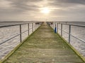 Sunrise over ocean. The empty wooden pier at moody colorful morning. Tourist wharf in bay at smooth sea Royalty Free Stock Photo