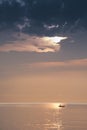 Sunrise over ocean showing silhouetted fishing boats and water reflecting golden colors and textures