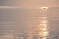 Sunrise over ocean showing silhouetted fishing boats and water reflecting golden colors and textures