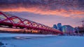 Sunrise over Peace Bridge in Calgary with frozen and snow-covered Bow River in Winter Royalty Free Stock Photo