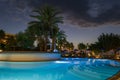 Sunrise over the pool and sunbeds. On the background of the sea coast. Big palm trees Royalty Free Stock Photo