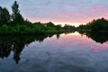 Sunrise over river with colorful clouds in sky, reflected in calm water. A picturesque early morning. Concept of nature Royalty Free Stock Photo