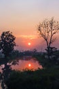 Sunrise over river in the morning with reflection from the water and silhouette of tree , rural landscape Royalty Free Stock Photo