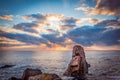 Sunrise over a rocky beach. Colorful clouds reflecting in the sea Royalty Free Stock Photo