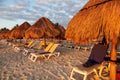 Sunrise over rows of lounge chairs and parasols at a Caribbean beach vacation Royalty Free Stock Photo