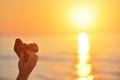 Sunrise over the sea coast. Fireball of the sun above the horizon in a colorful orange sky. Vintage SLR camera in hand in the for Royalty Free Stock Photo