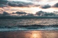 Sunrise over the sea after a storm. Dramatic clouds and rays of the sun illuminate sand and water. Yalta, Crimea Royalty Free Stock Photo