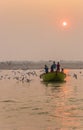 Sunrise over a small boat on the Ganges river in Varanasi Royalty Free Stock Photo