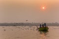 Sunrise over a small boat on the Ganges river in Varanasi Royalty Free Stock Photo