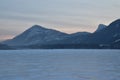 Pink Sunrise over a snowy mountain peak with frozen lake in the Royalty Free Stock Photo