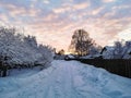 Sunrise over the snowy road in the village Royalty Free Stock Photo