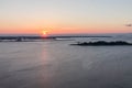 Sunrise over the wide river. The sun is in the left edge of the frame. Landscapes.