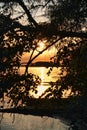 Sunrise through peephole in trees over Rend Lake in Illinois