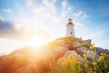 sunrise rays illuminating a hilltop lighthouse