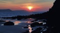 Sunrise reflected in the wet sand and rocks of Freshwater East beach Royalty Free Stock Photo