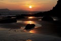 Sunrise reflected in the wet sand and rocks of Freshwater East beach Royalty Free Stock Photo