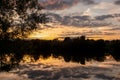 Sunrise reflections over peaceful English lake, with nobody in view Royalty Free Stock Photo