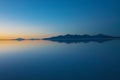 Sunrise on Salar de Uyuni in Bolivia covered with water, salt flat desert and sky reflections