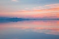 Sunrise on Salar de Uyuni in Bolivia covered with water, salt flat desert and sky reflections