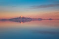 Sunrise on Salar de Uyuni in Bolivia covered with water, salt flat desert and sky reflections