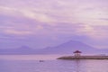 Sunrise at Sanur Beach with Mt Agung as a background. An island with gazebos on the beach against the background of the Royalty Free Stock Photo