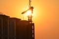 Sunrise scene housing society construction site crane machinary orange Sun and Skyline silhouette morning dawn day photography.