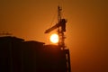 Sunrise scene housing society construction site crane machinary orange Sun and Skyline silhouette morning dawn day photography.