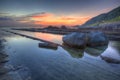 Sunrise scenery of a rocky coast in northern Taiwan, with beautiful reflections of golden sunlight