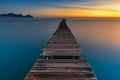 sunrise seascape with an old wooden dock leading out into the calm ocean waters of Alcudia Bay Royalty Free Stock Photo