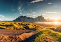 Sunrise shining over Vestrahorn mountain with clump of grass on black sand beach in summer at Iceland Royalty Free Stock Photo