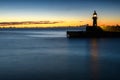 Sunrise and a lighthouse in Mevagissey harbour, Cornwall