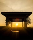 Sunrise with silhouette of trees and gazebo with sunray