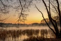 A sunrise on a small lake with fog and golden warm light. Royalty Free Stock Photo