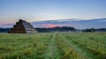 Sunrise with small village and stck of straw, Czech landscape