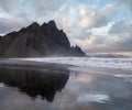 Sunrise Stokksnes cape sea beach and Vestrahorn Mountain with its reflection on wet black volcanic sand surface, Iceland. Amazing