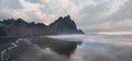 Sunrise Stokksnes cape sea beach and Vestrahorn Mountain with its reflection on wet black volcanic sand surface, Iceland. Amazing