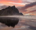 Sunrise Stokksnes cape sea beach and Vestrahorn Mountain with its reflection on wet black volcanic sand surface, Iceland. Amazing Royalty Free Stock Photo