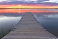 sunrise or sunset over a fishing dock with colorful clouds reflecting in the lake Royalty Free Stock Photo