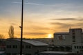 Sunrise or sunset over the town, beautiful colorful clouds over the buildings, roofs and chimney.